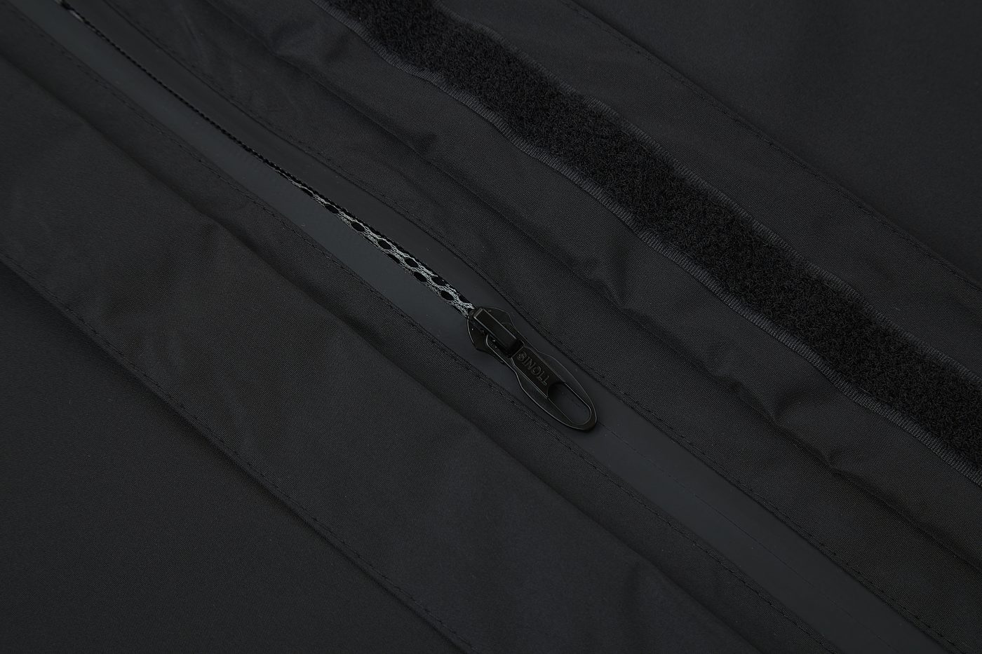 Waterproof zipper behind taped placket and hook-and-loop storm flap