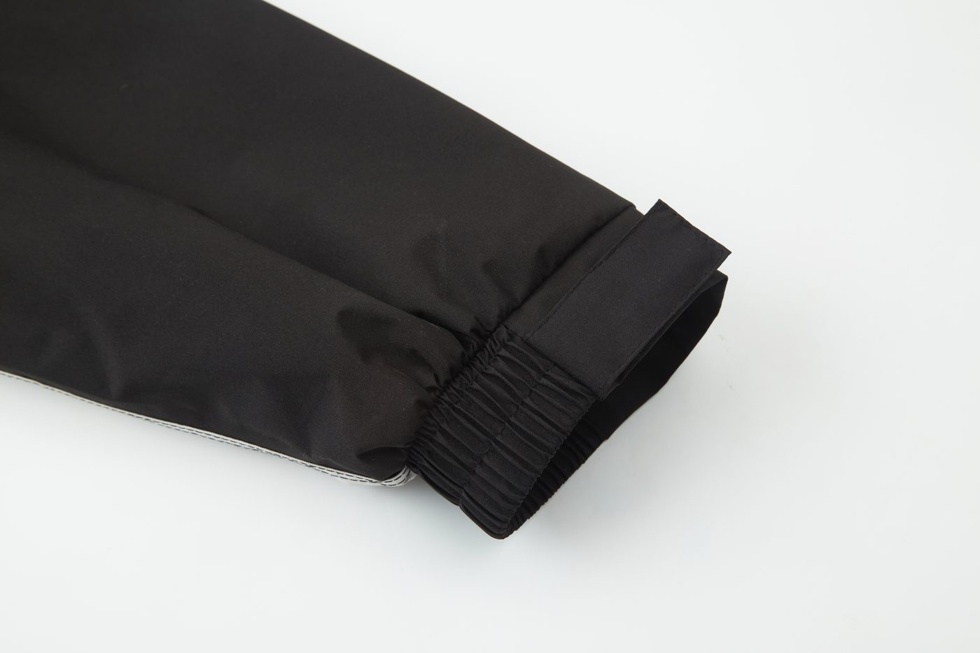 Trouser cuff with elastic gather and hook-and-loop tab